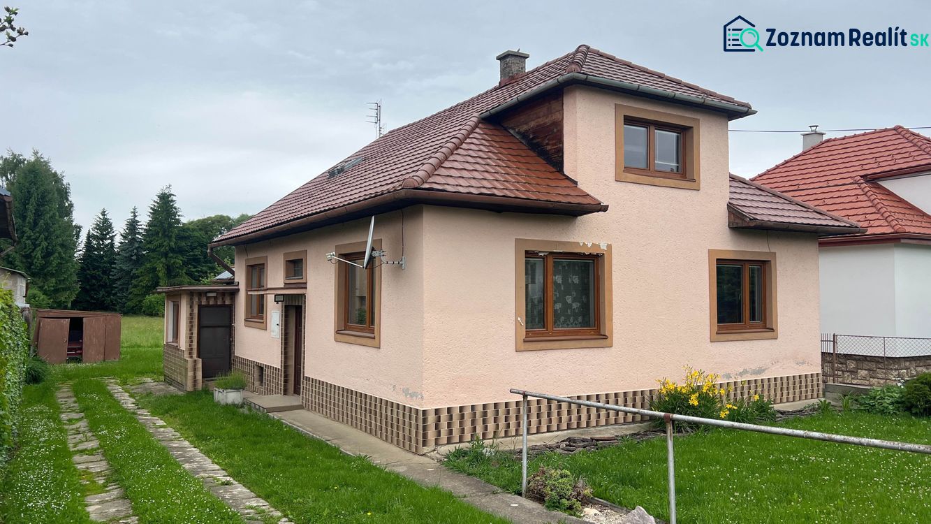 Családi ház Ľubelában piros tetővel, füves udvarral és külső raktárral.