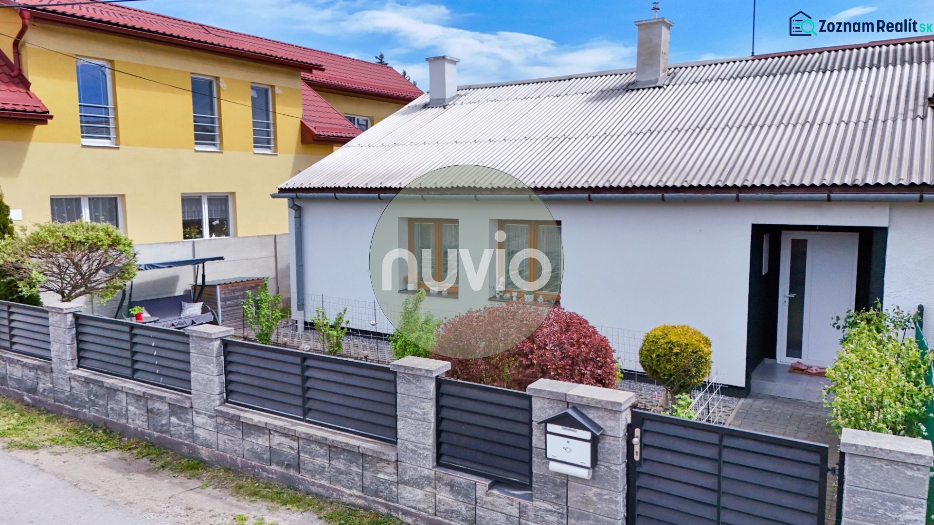 Családi ház Košťany nad Turcom-ban, rendezett kerttel és modern kerítéssel.