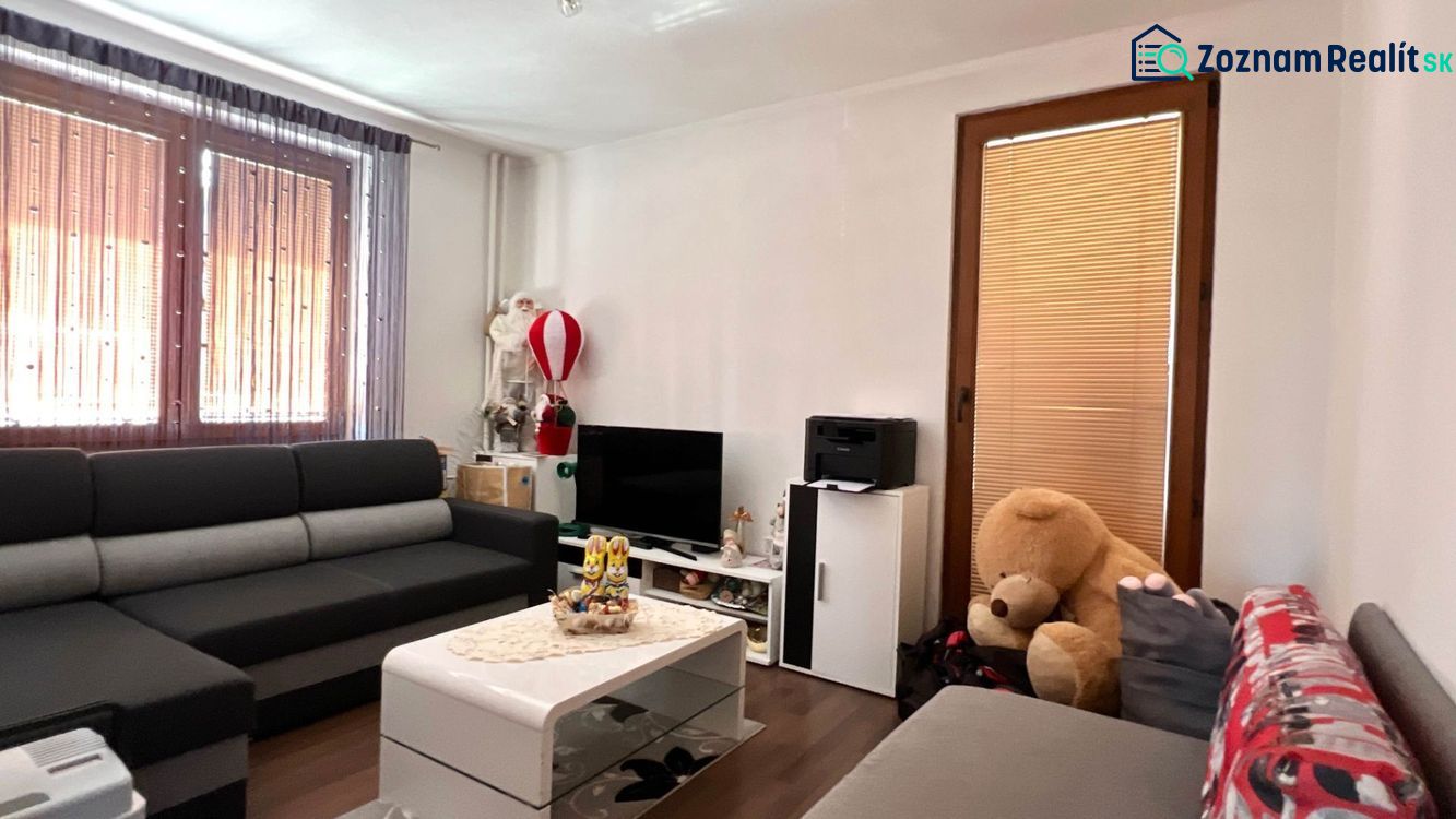 Családi ház nappalija kanapéval, televízióval és dekorációkkal.