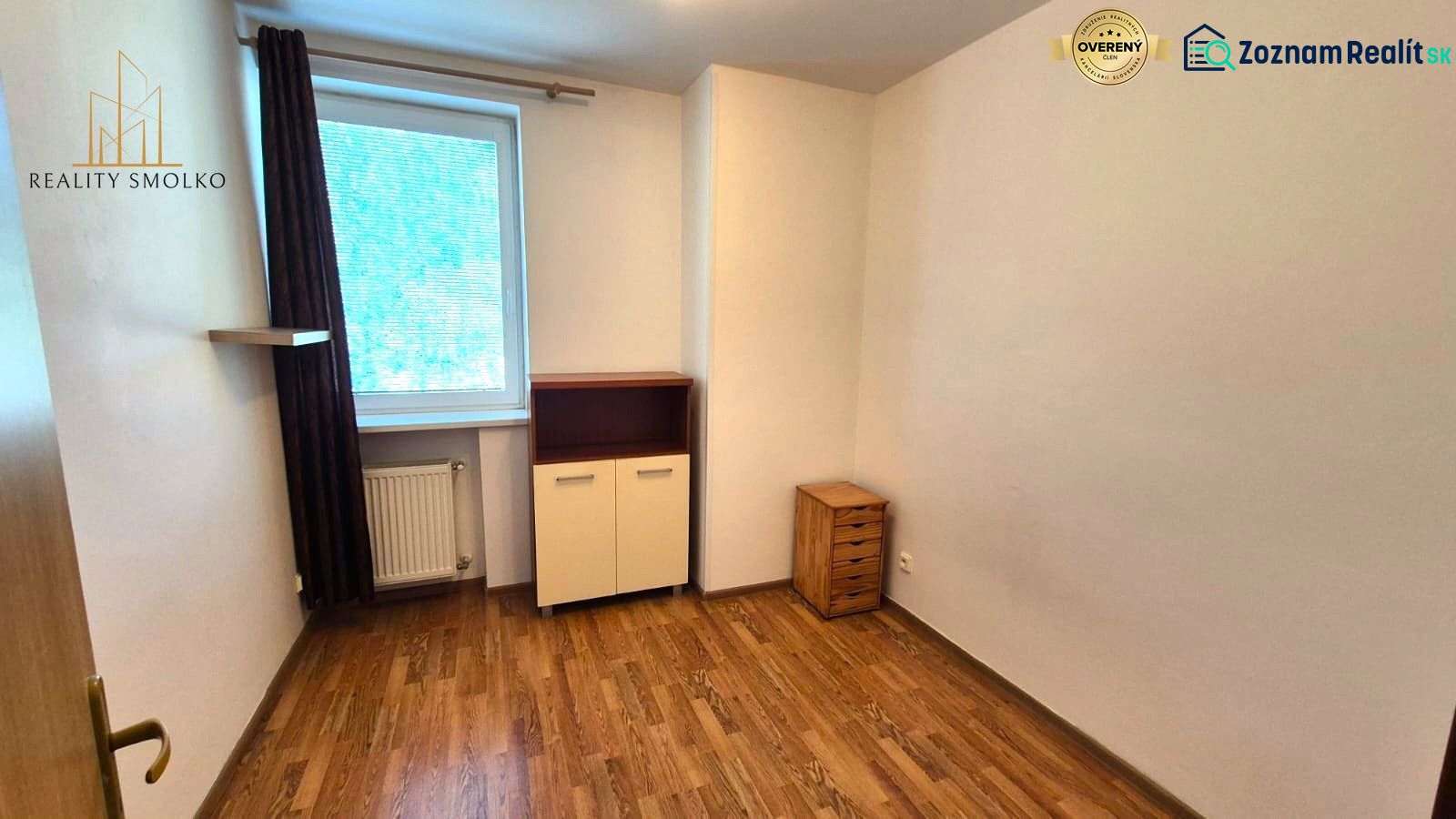 Szoba fa dekor padlóval egy egyszobás lakásban világos bútorokkal.