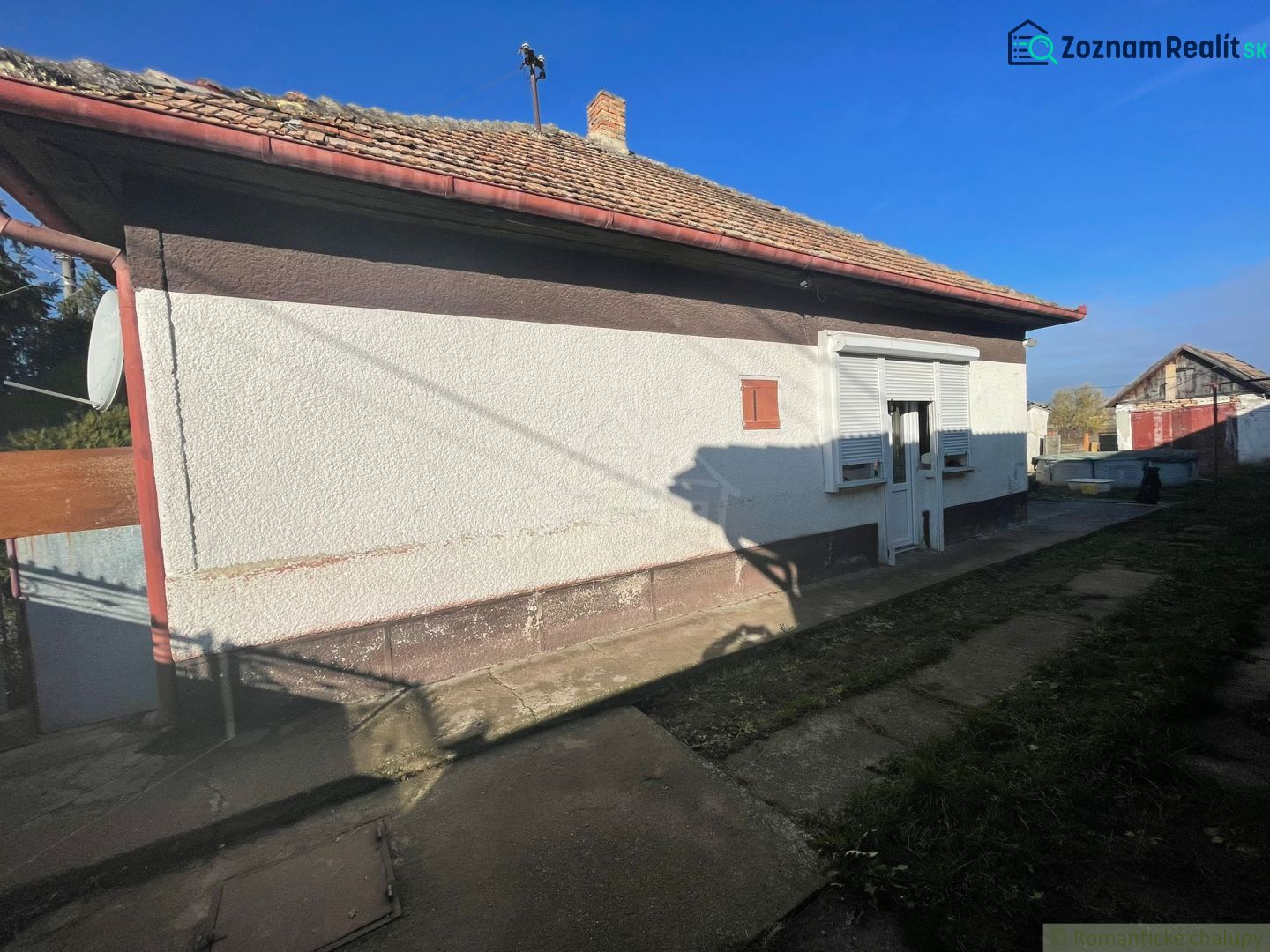 Családi ház Tardoskedden előreugró verandával és ferde tetővel.