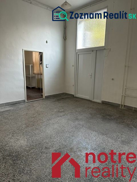 Iroda belső tér fehér falakkal és betonhatású padlóval.