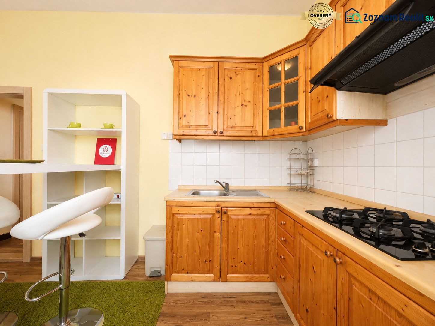 Konyha egy egyszobás lakásban fa szekrényekkel és fa dekorációjú padlóval.