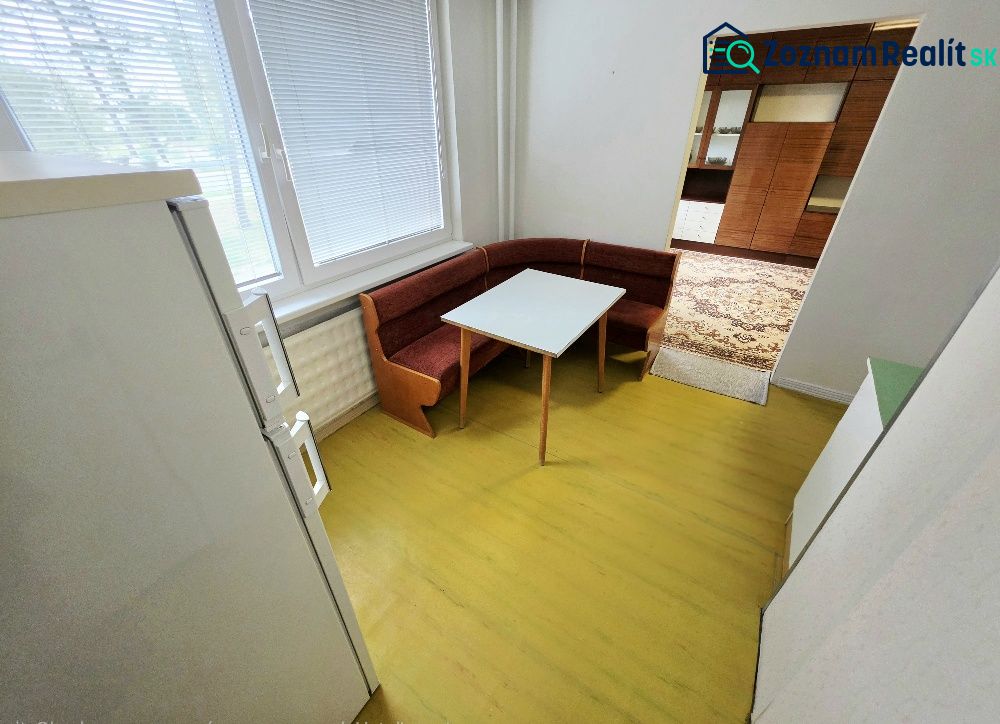Konyha háromszobás lakásban sarokpadkával és asztallal.