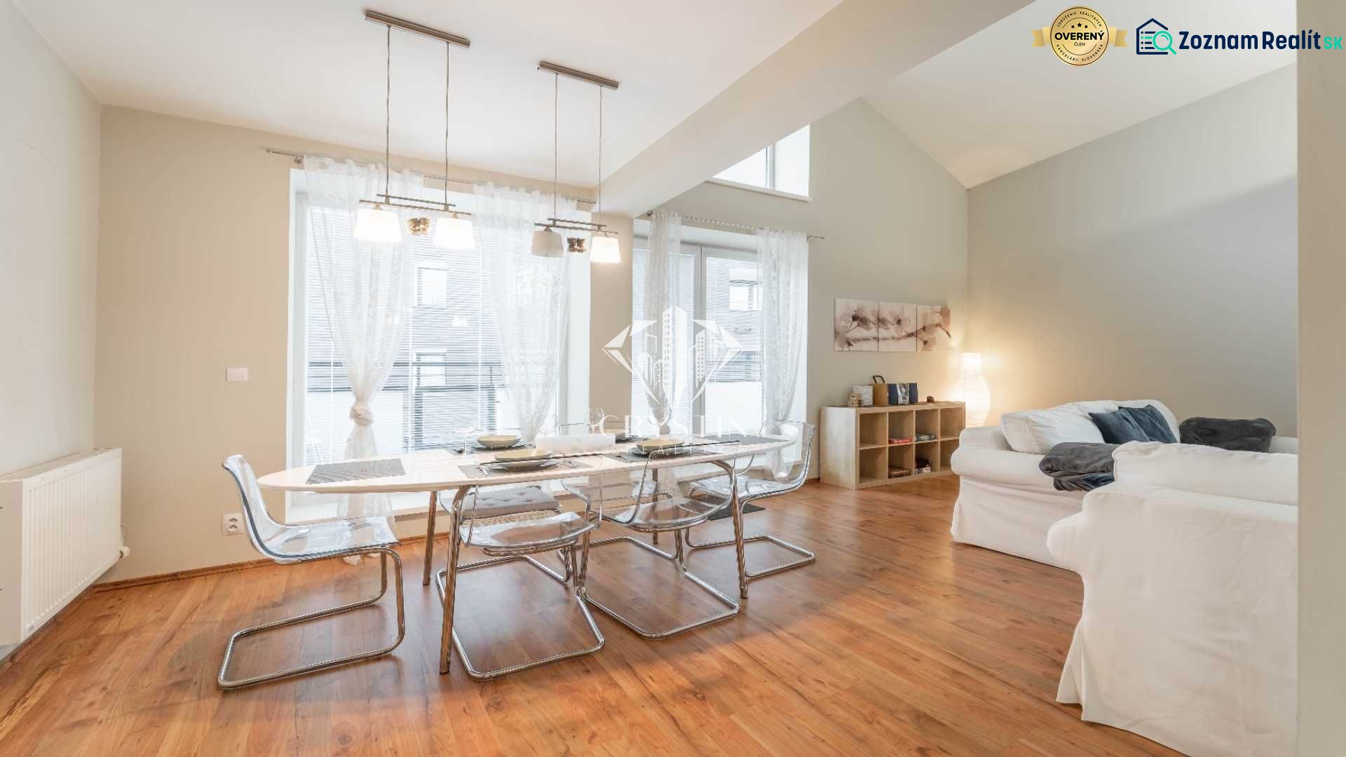 Rekreációs apartman étkezőasztallal, kényelmes kanapékkal és fa dekorációjú padlóval.