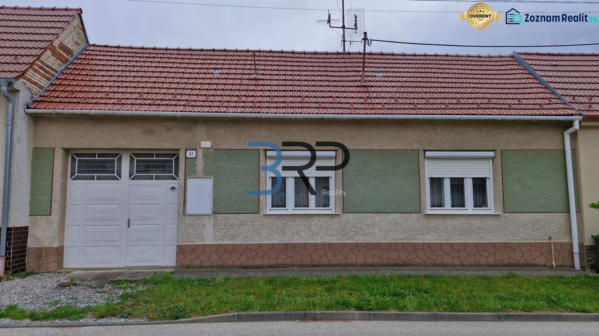 Családi ház Mokrý Hájban piros tetővel és garázsajtókkal.