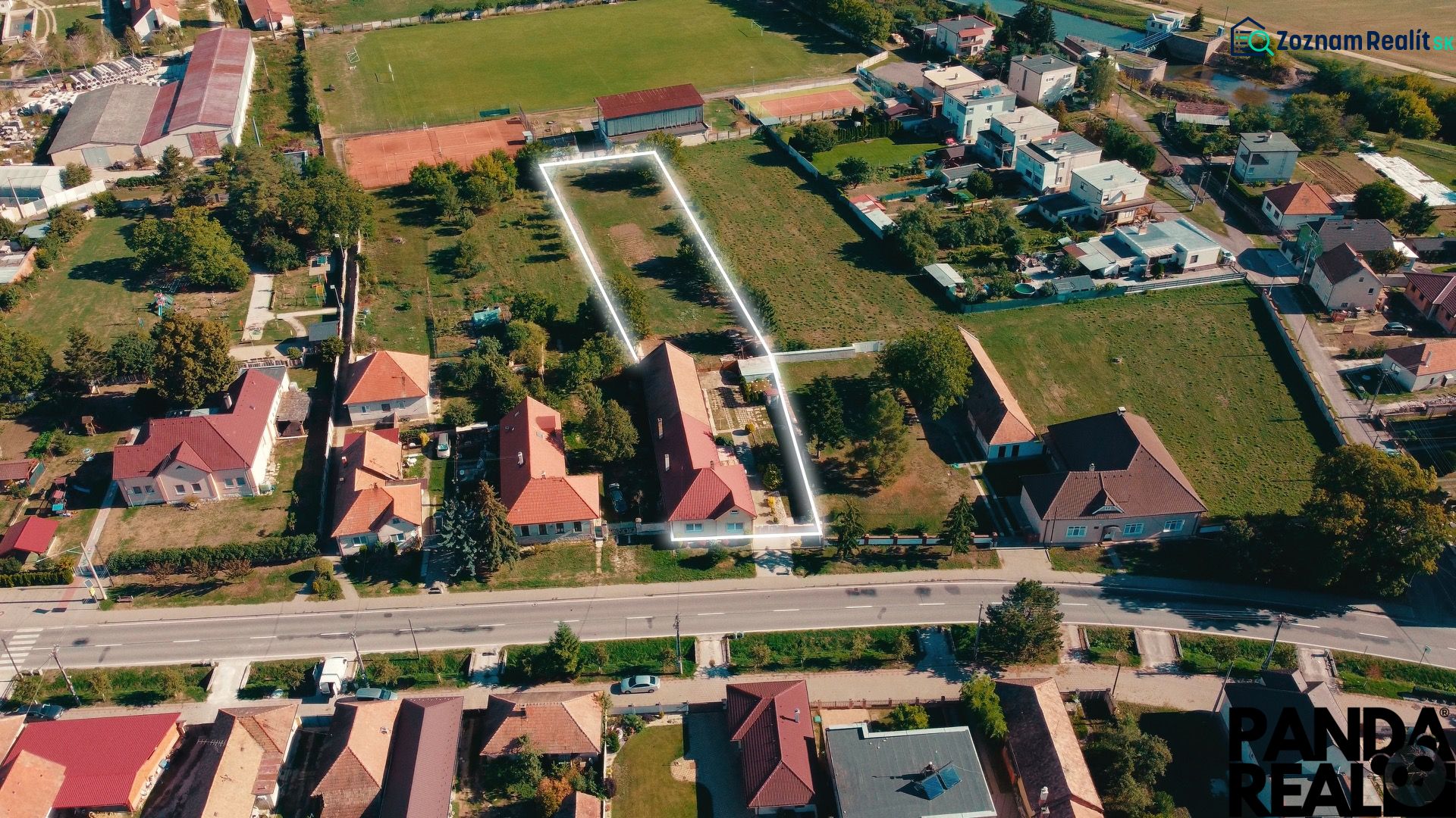 Családi házak és kertek légi felvétele Nadlicéken, zöldövezettel és utakkal körülvéve.