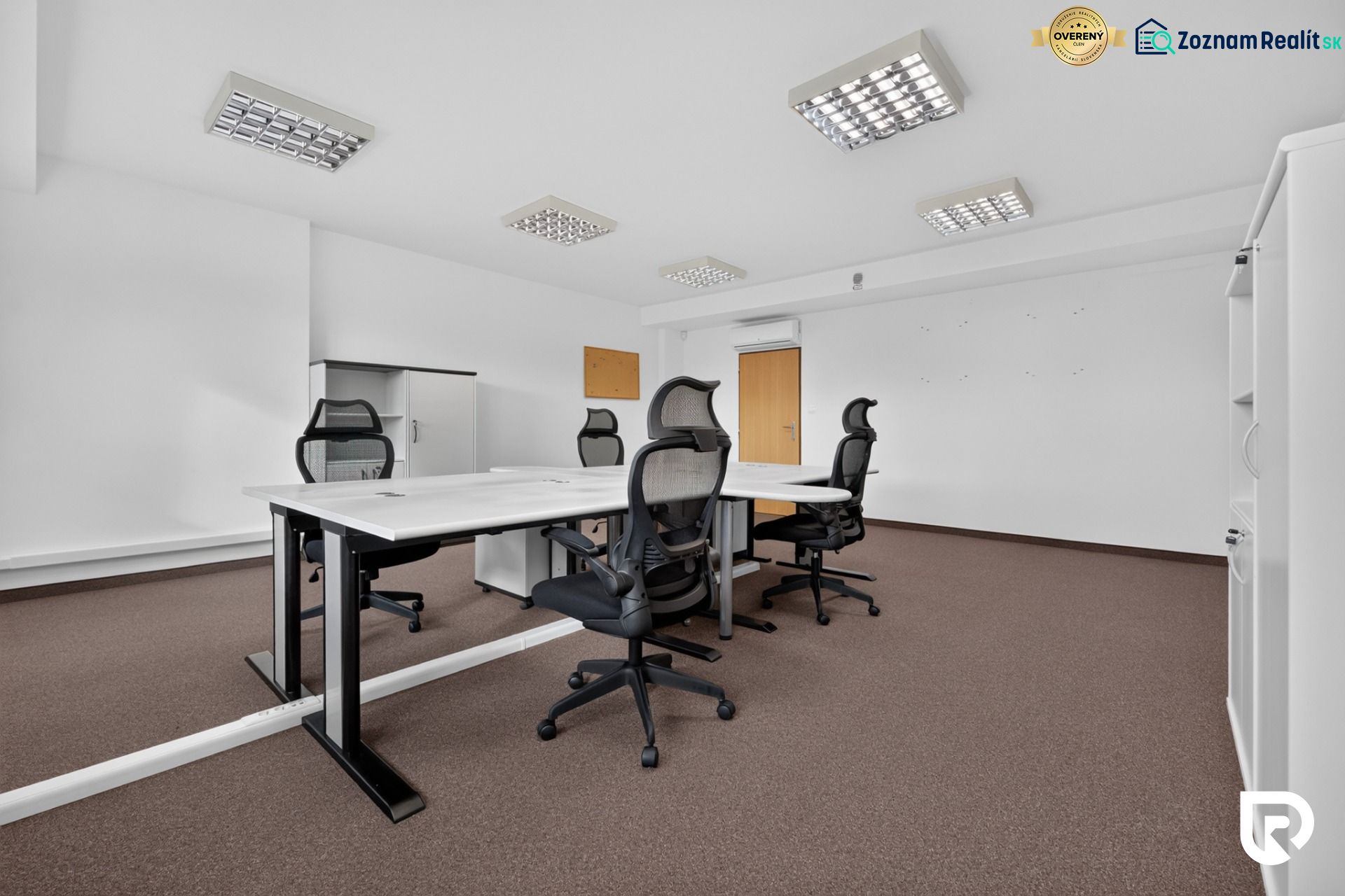Irodák konferenciaasztallal, ergonomikus székekkel és tárolószekrényekkel.