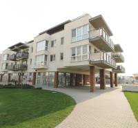 Budova na ulici Smaragdová s obchodnými priestormi a balkónmi, vhodnou pre 3-izbový byt.