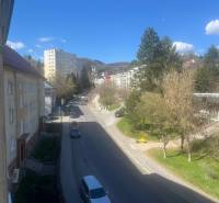 Pohľad na ulicu a križovatku z 2-izbového bytu; stromy, autá, bytové domy, slnečný deň.