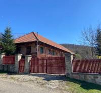 Rodinný dom s šikmou strechou, dreveným plotom, záhradou; ideálny pre rodiny.
