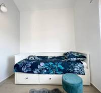 Nyaraló apartman ággyal és kék mintás ágyneművel.