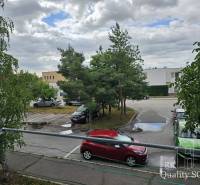 Parkoló a Szenci Zsitva utcában autókkal és fákkal.