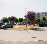 Parkoló és modern lakóházak Trencsénben játszótérrel.