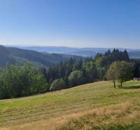 Panorámás kilátás az erdős dombokra és rétekre Olešnában, alkalmas lakóterületek kialakítására.