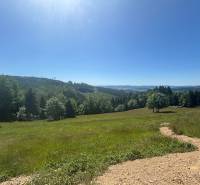 Lakóterületek Olešnában, erdőkkel körülvéve, panorámás kilátással a dombokra.