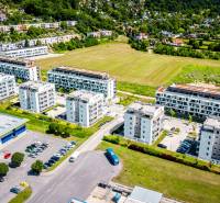 Légi felvétel a púchovi Dlhé lúky lakótelepről és parkolóról, kilátással egy kétszobás lakásra.