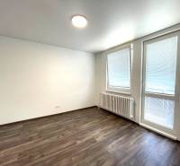 Izba s výstupom na balkón s laminátovou podlahou a oknami v 4-izbovom byte.