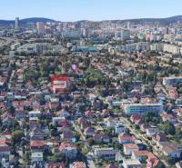 Légi felvétel családi házakról Pozsonyban, zöld terület és városi panoráma.