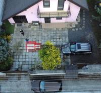 Családi ház Pílán tágas udvarral, parkoló autókkal és gondozott kerttel.