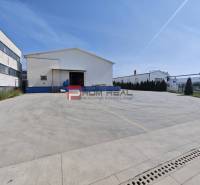 Raktárak és csarnokok a Modrai Šúrska utcában nagy betonparkolóval.