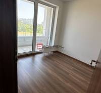 Szoba fa padlóval és erkéllyel egy 2 szobás lakásban.