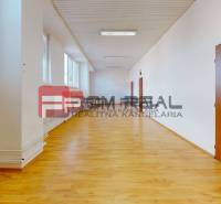 Tágas folyosó fa padlóval és ajtókkal a raktár- és csarnokterekben.