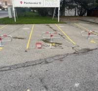 Parkolóhelyek blokkolókkal a Púchovská utcán, Pozsony III, a garázsok előtt.