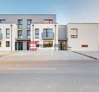 Épület a Bottova utcán, modern építészet, parkoló és családi ház a háttérben.