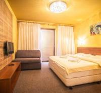 Hálószoba nyaraló apartmanban franciaággyal, kanapéval és televízióval.