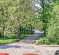 A Staničná utca Nagyszombatban fákkal szegélyezett, nyugodt városi jelenetet ábrázol.
