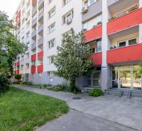 Vörös erkélyekkel és zöld növényzettel rendelkező lakóház a pozsonyi Petržalka városrészben, a Wolkrova utcában.