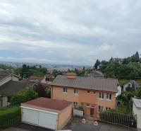 Kilátás családi házakra Pozsonyban, a Kolibán, a Jalovcová utcában, a város panorámájával.