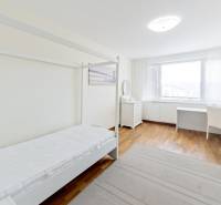 Világos szoba egy 3 szobás lakásban ággyal és tárolóhellyel.