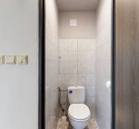 Fürdőszoba WC-vel, világos csempékkel burkolva, egy háromszobás lakásban.