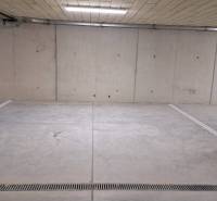 Parkolóhely egy föld alatti garázsban betonfalakkal és padlóval.