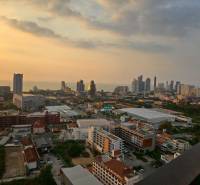 Naplemente kilátás a város panorámájára egy háromszobás lakásból Pattayában.