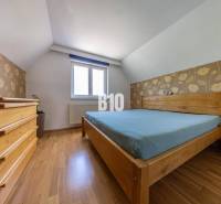 Hálószoba fa bútorokkal családi házban, virágos tapéta, fa padló.