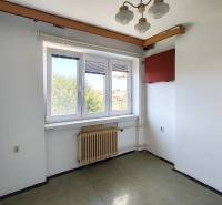Egy családi ház szobája ablakkal, radiátorral, csillárral és a sarokban látható konnektorral.