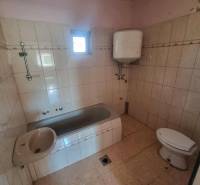 Fürdőszoba családi házban káddal, mosdóval, WC-vel és bojlerrel.