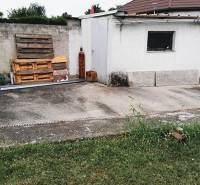 Udvar egy családi ház mellett a 2473 Potzneusiedl-ben betonfelülettel és fa raklapokkal.