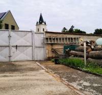 A családi ház bejárati udvara Potzneusiedl 2473-ban, kapuval és felhalmozott fával.
