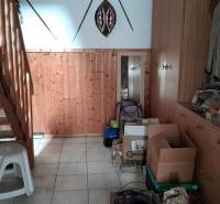 Fa lépcső és tárolóhely egy családi házban dobozokkal és kabátokkal.