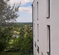 Fehér homlokzatú villa Hainburg an der Donau városában, kilátással a kertre és a fákra.