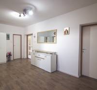 Családi ház belső tere fehér bútorokkal, fa dekoros padlóval és nagy tükörrel.