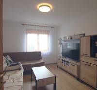 Nappali kanapéval, TV-vel és bútorokkal egy családi házban.