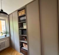 Gardrób egy 4 szobás lakásban fa padlóval és polcokkal tárolóhelyekhez.