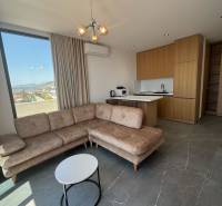 Nyaraló apartman nappalija sarokkanapéval, kilátással és konyhasarokkal.