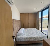 Hálószoba a nyaraló apartmanban kényelmes ággyal, ízléses berendezéssel és erkéllyel.