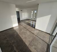Nyaraló apartman belső tere nagy ablakokkal és fényes csempével.